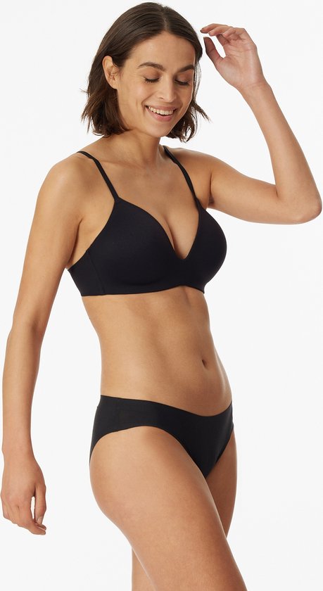 Model met zwarte, beugelloze bh met voorgevormde cups en dunne bandjes.