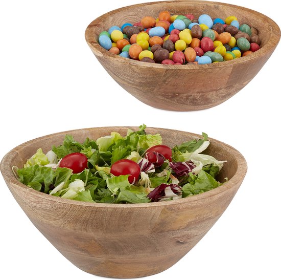 Twee houten kommen: de bovenste gevuld met kleurrijke snoepjes, de onderste met een groene salade en kerstomaatjes.