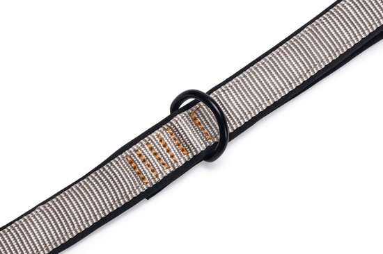 Close-up van een lichtgrijze nylon band met een zwarte metalen ring.