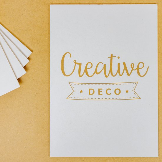 Witte A3 kaart met gouden tekst "Creative DECO" en een lint-icoon.