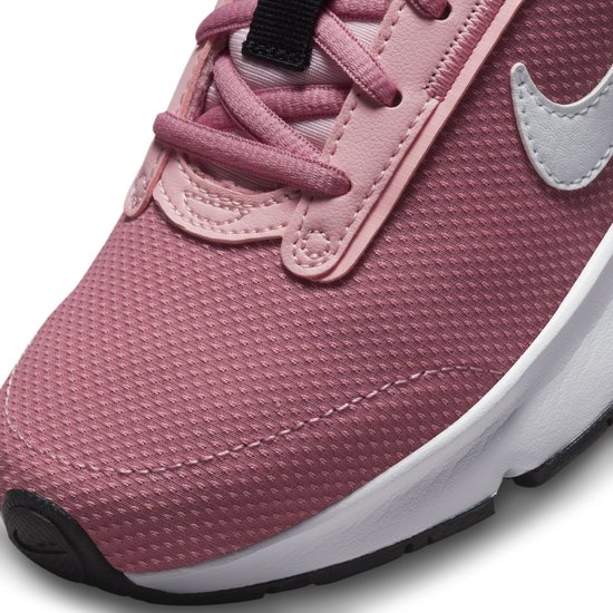 Close-up van de roze Nike sneaker, met de focus op de veters en swoosh.