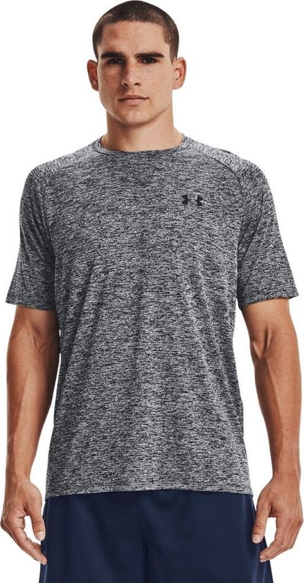 Man draagt een donkergrijs gemêleerd Under Armour sportshirt met korte mouwen en een zwart logo.