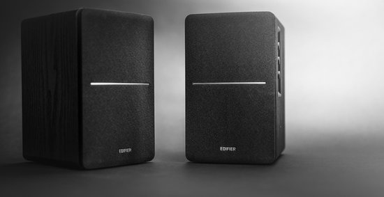 Twee Edifier speakers met houten zijkanten en zwarte stoffen voorkanten.