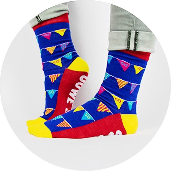 Personen dragen blauwe sokken met slingers en gele, roze accenten, en rode sokken met witte tekst.
