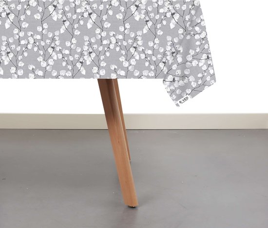 Grijze tafel met een wit bloemenpatroon, close-up op de hoek van het tafelkleed.