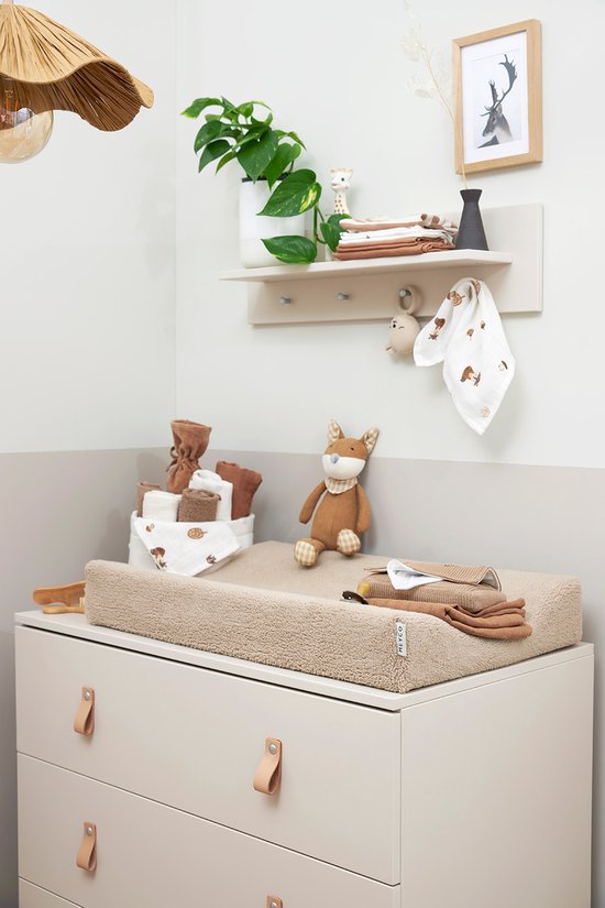 Babykamer met commode, aankleedkussen met doekjes en een speelgoedvos.