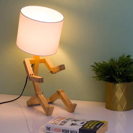 Zittende houten tafellamp met witte kap, witte kap, naast een boek met de titel 'The 4-Hour Work Week'.