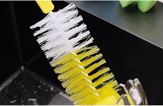 Gele en witte flesborstel die wordt gebruikt om een kraan of gootsteen schoon te maken.
