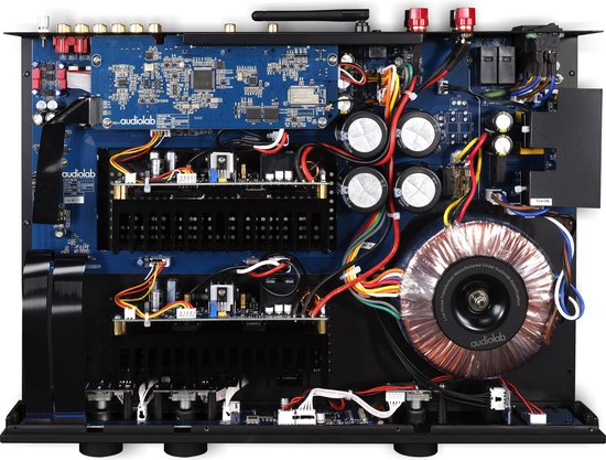 Bovenaanzicht van zilverkleurige audiolab 7000A versterker met open behuizing, elektronische componenten zichtbaar.