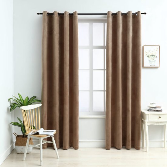 Twee beige fluwelen gordijnen hangen voor een raam in een woonkamer, naast een stoel met plant.