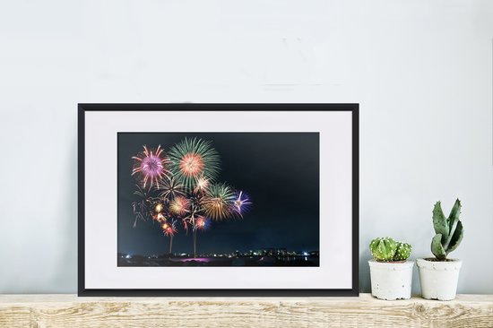 Photo en cadre - Une image de feu d'artifice dans une ville pendant le Nouvel An Cadre photo noir avec passe-partout blanc, moyen 60x40 cm - Affiche sous cadre (Décoration murale salon / chambre)