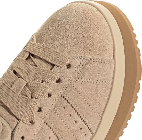 Close-up van de beige suède neus en veters van de adidas Campus instapper.