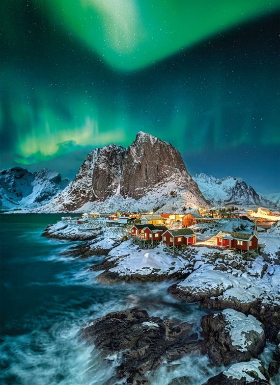 Noorse huisjes in de sneeuw onder de aurora borealis.