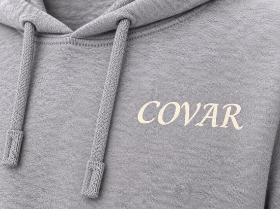 Close-up van grijze hoodie met 'COVAR' print op linkerborst en touwtjes capuchon.