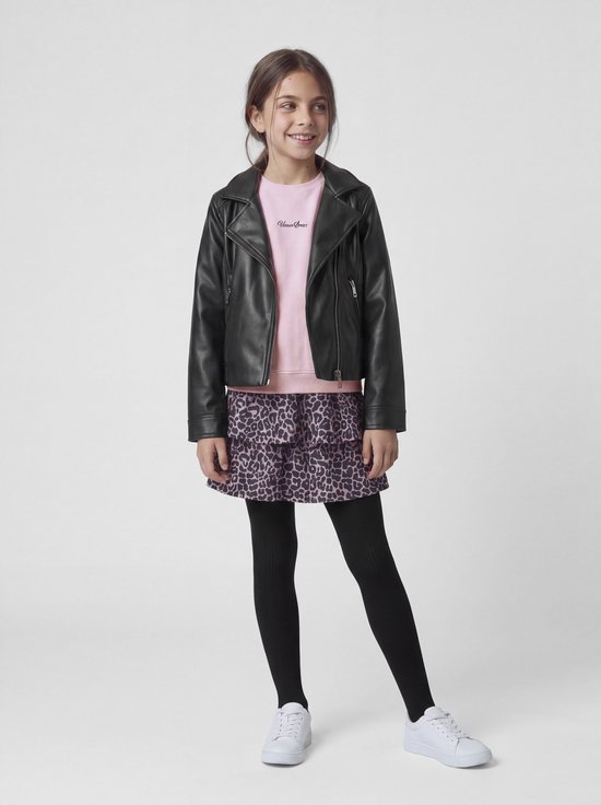Meisje draagt een roze rok met luipaardprint, zwart leren jasje, roze 'Urban Sport' trui, zwarte maillot en witte sneakers.