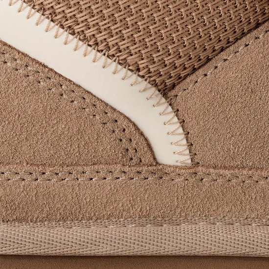 Close-up van de textuur van een lichtbruine UGG Lowmel sneaker met suède, mesh en een gestikte witte rand.