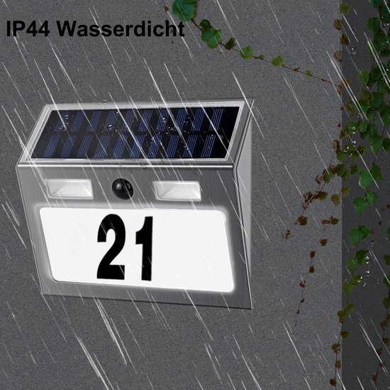 IP44 waterdicht zonne-energie huisnummer '21' gemonteerd aan een grijze muur tijdens een regenbui.