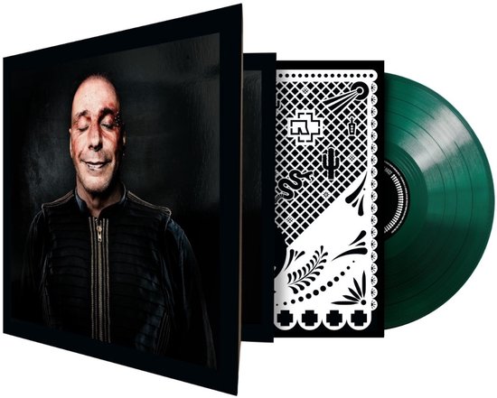 Zijzicht op een platenhoes met een lachende man in zwart jasje, naast een groene vinylplaat.