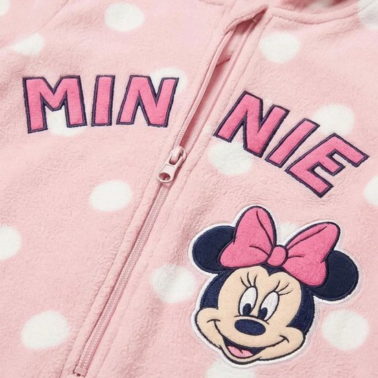 Detailopname van roze onesie met witte stippen, rits, tekst "MINNIE" en Minnie Mouse-patch.