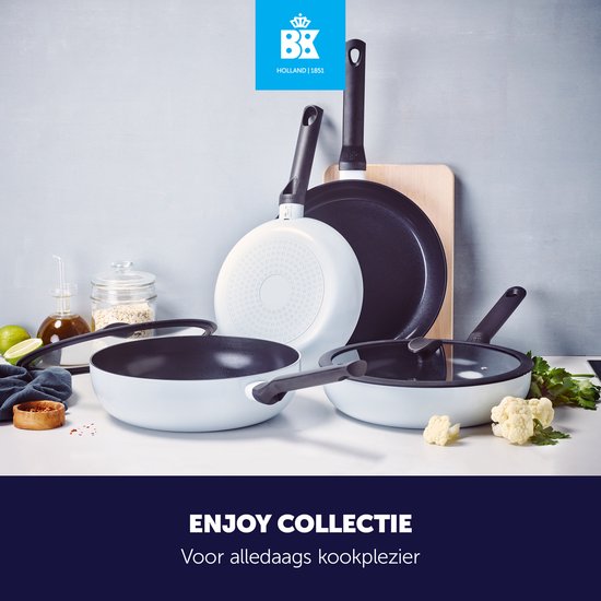 Set van BK Enjoy pannen in blauw-grijs met zwarte deksels en handgrepen, op een aanrecht met groenten en ingrediënten.