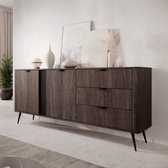 Donker eiken dressoir met zwarte pootjes, drie lades en een geribbelde kastdeur in een modern interieur.