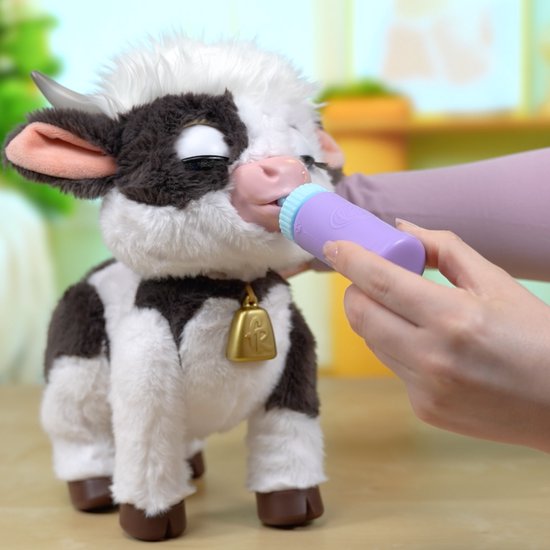 Interactieve FurReal Riley koe met ogen dicht, terwijl ze uit een lila flesje drinkt.