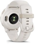 Achterkant van de Garmin Vivoactive 5 in ivoor, met hartslagsensoren en oplaadpunten.