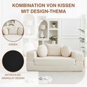 Beige ribfluwelen bank met ronde en vierkante kussens en anti-slip bodem.