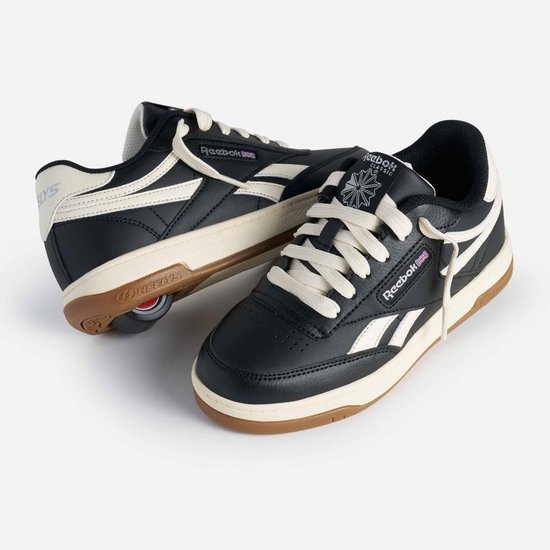 Zwarte Heelys sneakers met crèmekleurige accenten, veters en op de zool gemonteerde rollen.