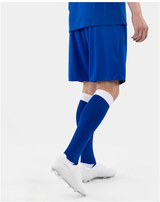 Un homme porte un short de sport bleu et des chaussettes assorties à bords blancs. Chaussures de football blanches.