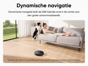 Zwarte robotstofzuiger met dynamische navigatie, op een houten vloer met een vrouw op een bank en een hond.