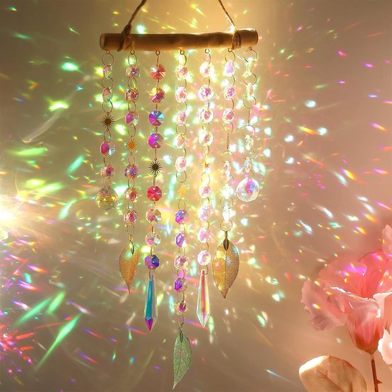 Kristallen zonnewijzer hangend, met een regenboog van licht dat op de achtergrond wordt geprojecteerd, met veelkleurige kralen en bladbedeltjes.