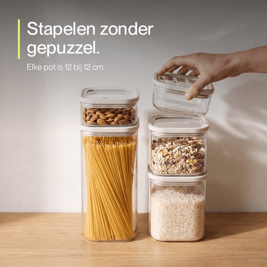 Une main ferme un bocal Safecourt rempli d'amandes sur une pile d'autres bocaux remplis de spaghettis, muesli et riz.