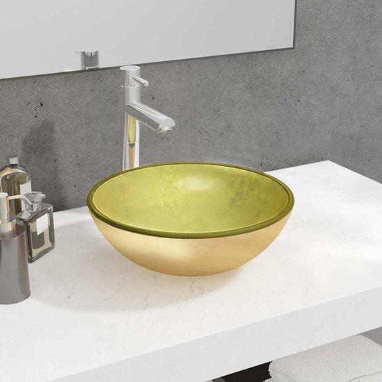 Une vasque ronde dorée sur un meuble-lavabo blanc avec un robinet chromé.