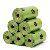 Groene poepzakjes met zwarte pootafdrukken, gestapeld.