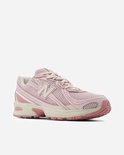 Roze New Balance sneaker met witte veters, crèmekleurige zool en beige accenten.