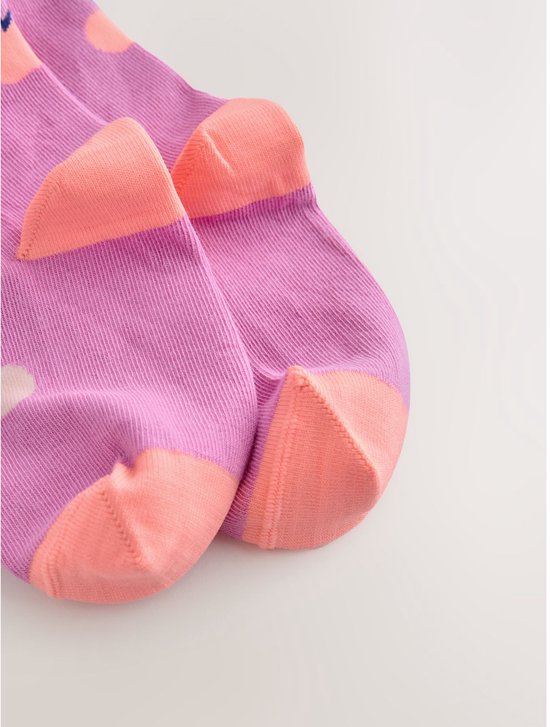 Roze sokken met perzikkleurige tenen en stippen.