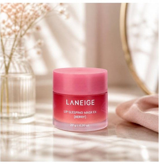 Pot rose Laneige Lip Sleeping Mask EX [Berry] sur une table avec des ombres et un vase.