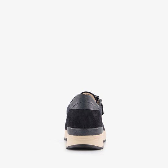 Achterkant van een donkerblauwe suède sneaker met ritssluiting en beige zool.
