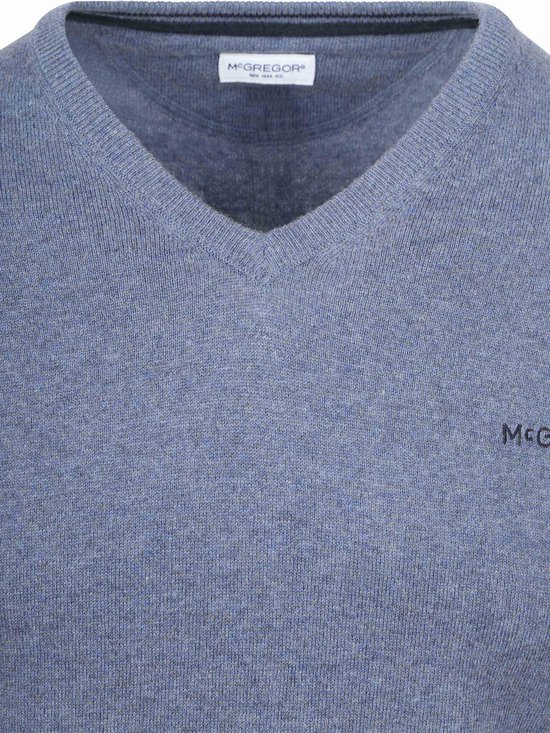 Close-up van de hals van een blauwe V-hals trui van merinowol met McGregor label.