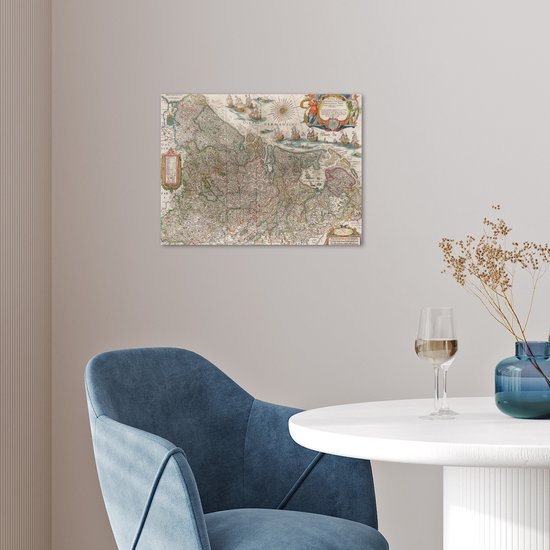 Carte historique des Pays-Bas accrochée à un mur au-dessus d'un fauteuil bleu.