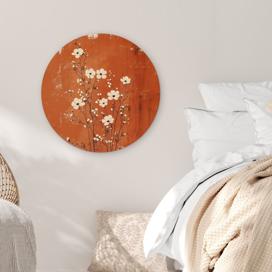 Cercle mural rond avec des fleurs blanches sur fond rouille, dans une chambre à coucher.