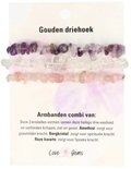 Drie armbanden met paarse, witte en roze steentjes op een kaart.