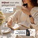 Vrouw met een elegante outfit en een gouden smartwatch, drinkend uit een mok.
