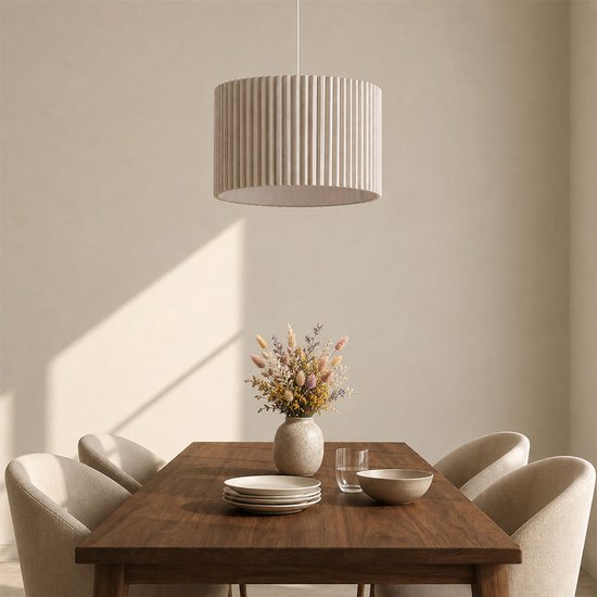 Suspension beige à plis verticaux au-dessus d'une table en bois avec des fleurs.