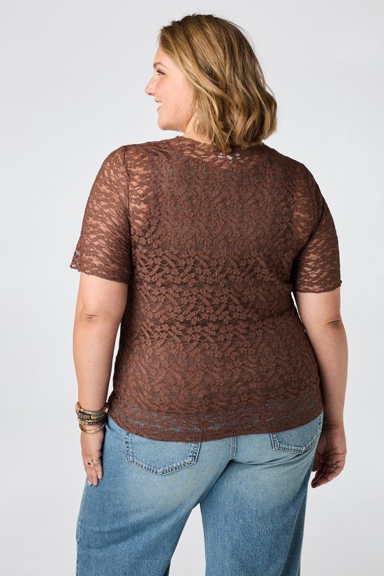 Vrouw van achteren gezien in bruine kanten top en jeans.