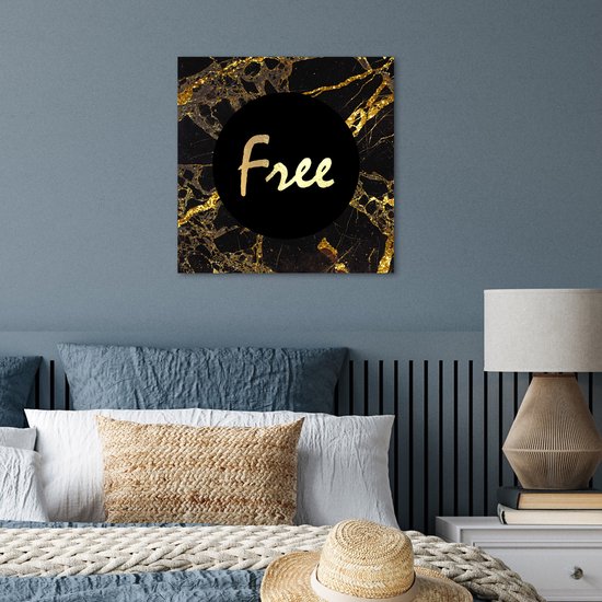 Affiche marbre noir, accents dorés et texte "Free". Accroché au-dessus d'un lit dans une chambre.