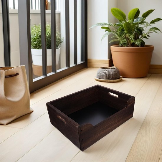 Donkerhouten krat op een lichte vloer, bij een kamerplant en een beige tas.