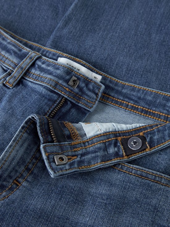 Sluiting van de blauwe jeans met knoop, rits en merklabel 'name it 10y'.