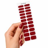 Een hand houdt een vel met 22 dieprode gellak stickers vast. De nagels zijn ook voorzien van de stickers.